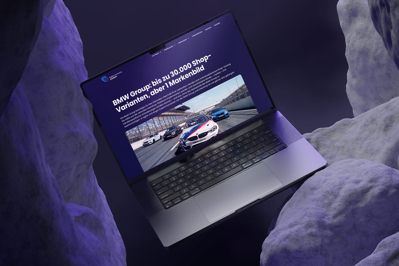 Laptop zeigt BMW Group Use Case auf der Website von Digital Commerce Experts mit Rennstreckenbild und Headline zu 30.000 Shop-Varianten