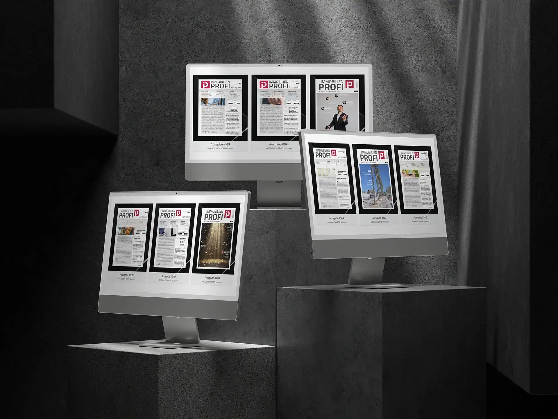 Website-Mockup des Immobilienprofi Magazins mit mehreren Monitoren, digitalen Fachmagazin-Ausgaben und Betonhintergrund.